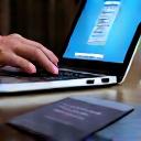 Une main tapant sur un clavier d'ordinateur avec des billets d'avion et un passeport à côté, symbolisant la Réservation et Préparation